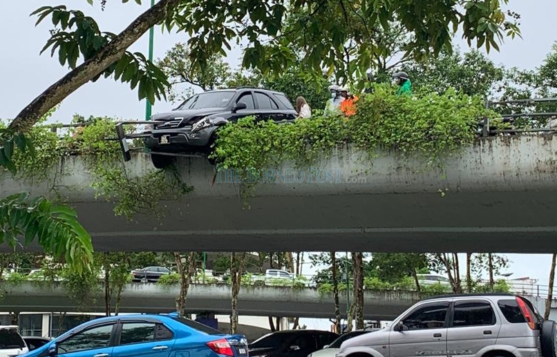 SUV teeters over Satok Flyover after accident, driver escapes unhurt