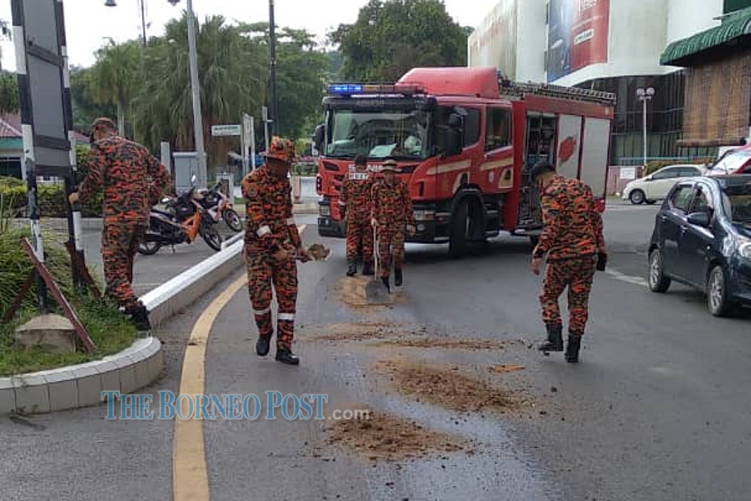 Bomba deals with oil spill on the road in Miri